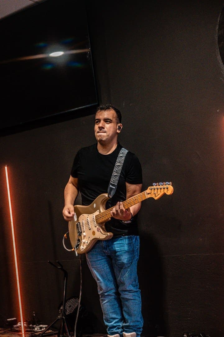 Un guitarrista de la banda de alabanza tocando durante el servicio